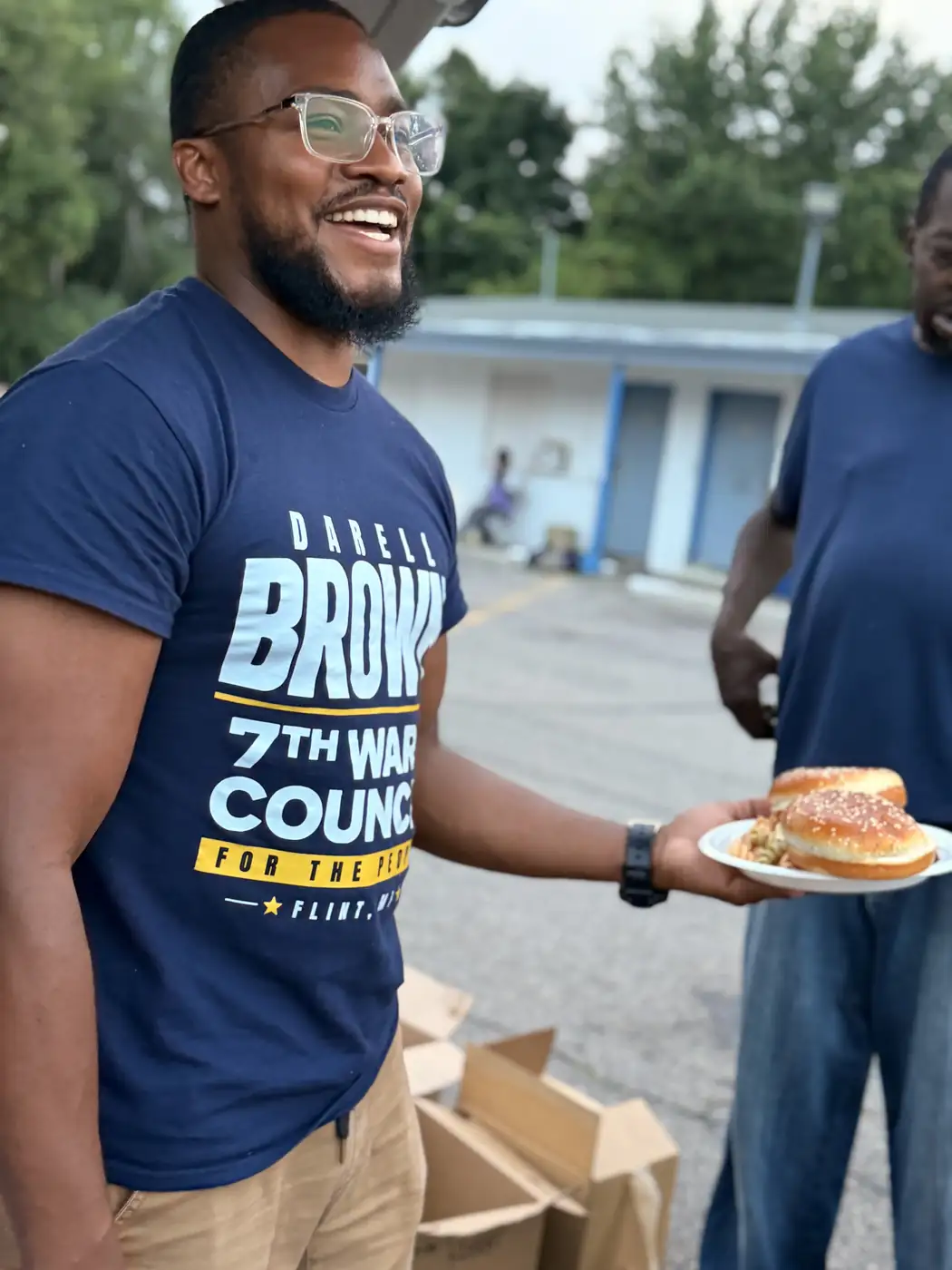 Darell Brown serving food to neighbors outdoors