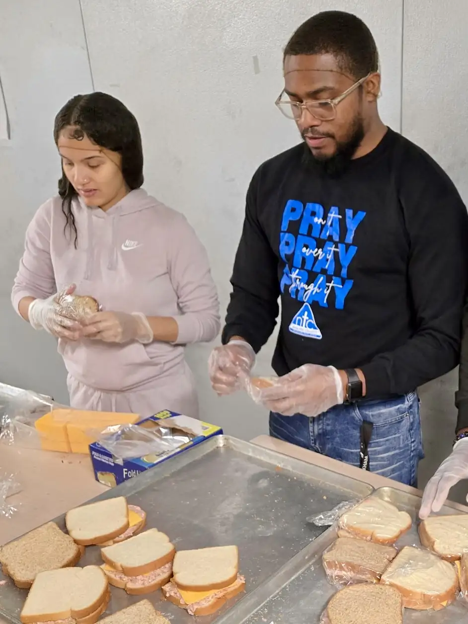 Darell Brown preparing food with another volunteer